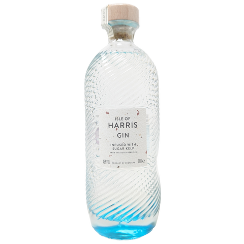 a bottle of the isle of harris gin from the isle of harris distillery with its iconic blue bottom fading into a clear bottle with copper flakes in the wite label