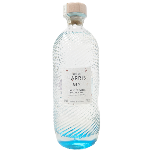 a bottle of the isle of harris gin from the isle of harris distillery with its iconic blue bottom fading into a clear bottle with copper flakes in the wite label