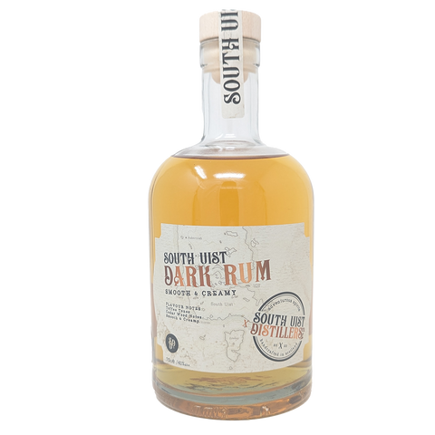 Bottle of South Uist Dark Rum from the South Uist Distillery. Bottle label has the South Uist branding with a light map of the south uist island in the background. Rum is gold in colour. 