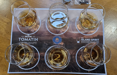 Looking over the top of the Tomatin whisky tasting drams filled with whisky. 